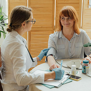 A medical professional checks a woman's arm, likely for an immigration physical.